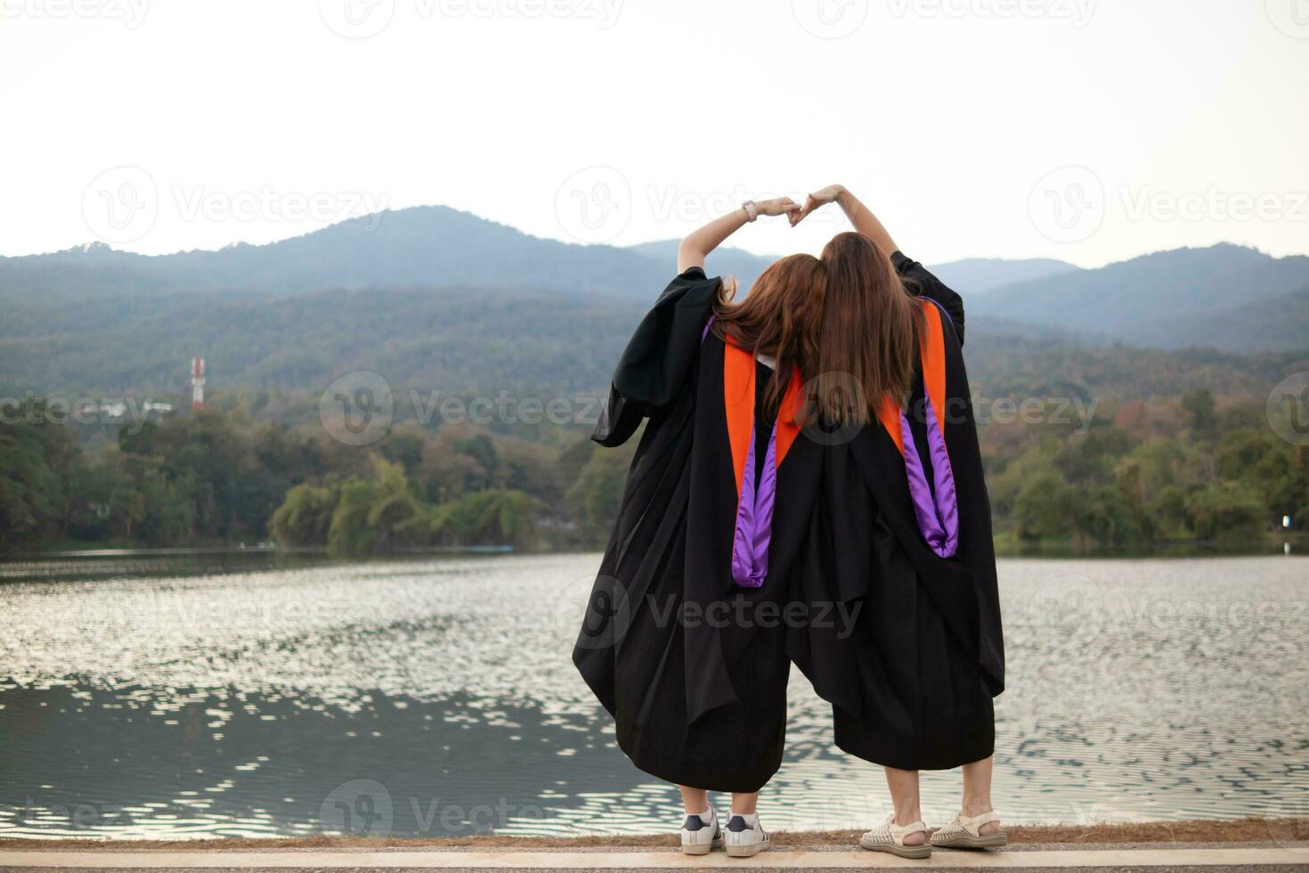 woman holds her hand above her head to form heart symbol that represents love, friendship and kindness between lovers and friends. heart symbol is concept that represents friendship, love and kindness. photo