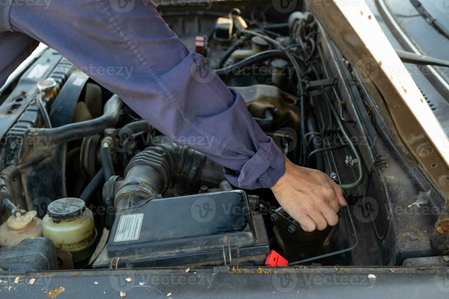 car mechanic is checking condition of engine to make it ready for use and mechanic is still maintaining worn out equipment to return to normal operation. checking engine conditions before traveling photo