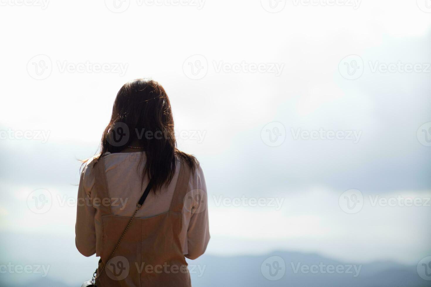 Back scene of woman alone with feeling lonely and depressed on blurred background of beautiful nature scenery . concept of woman who had to be alone in past was depressed when she encountered problems photo