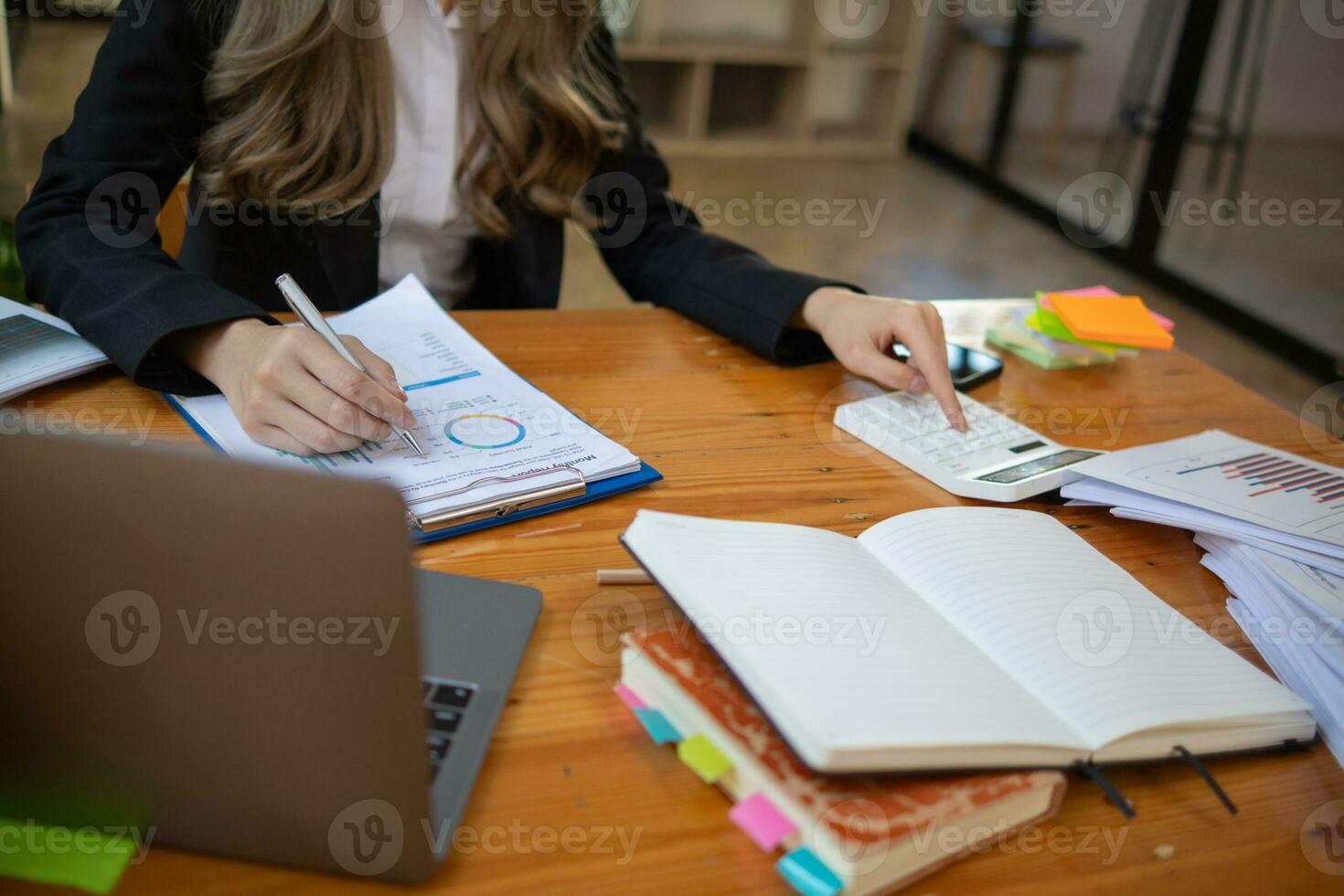 An accountant is using a calculator to accurately calculate the income and expenses and is using the calculator to review the company investment results and profits Copy Space for text photo