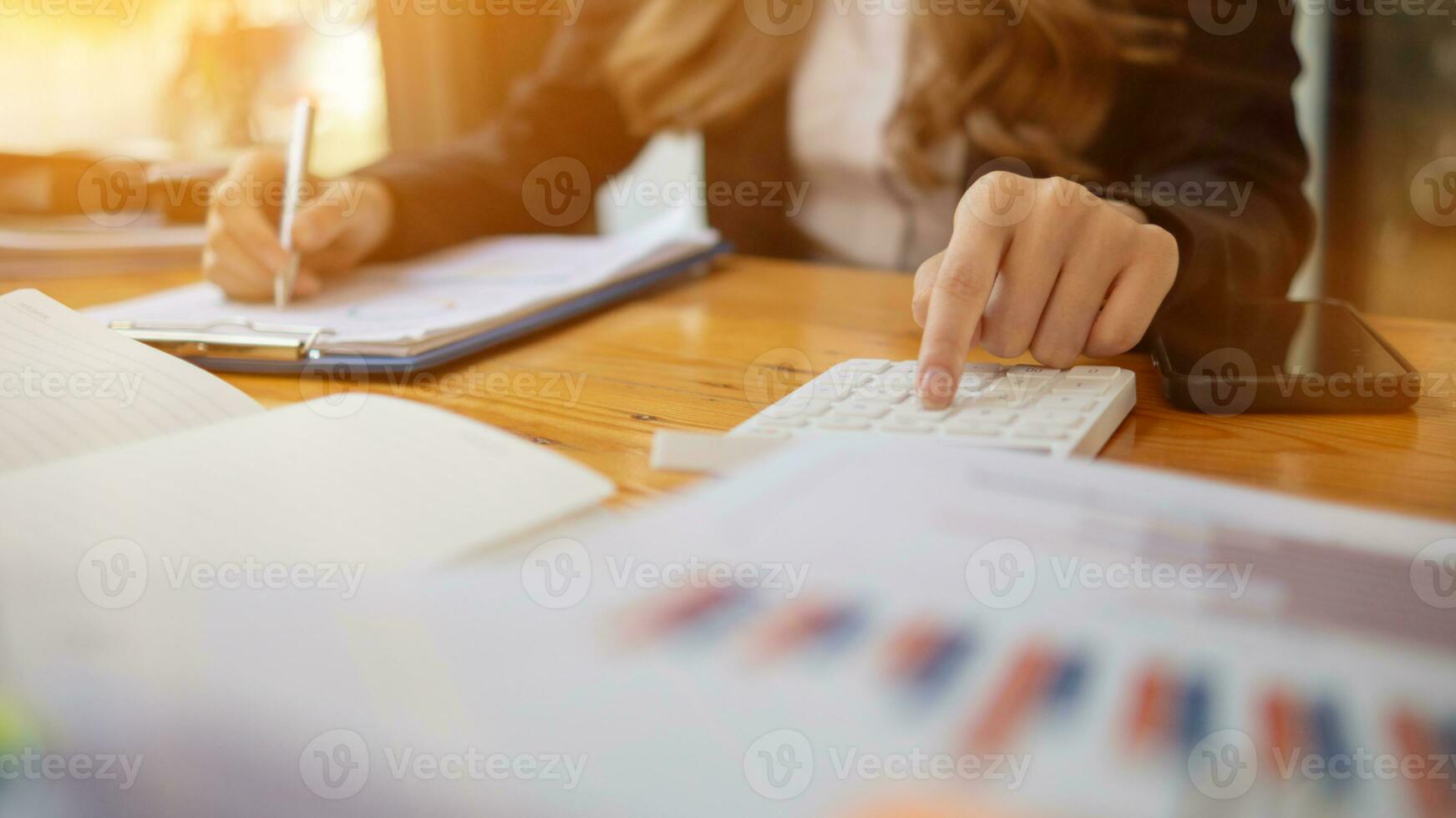 An accountant is using a calculator to accurately calculate the income and expenses and is using the calculator to review the company investment results and profits Copy Space for text photo