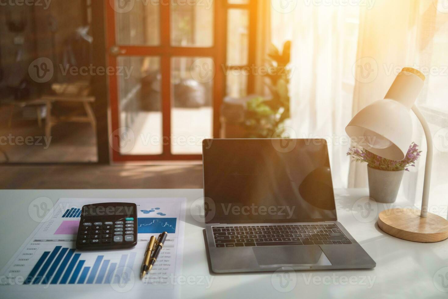 Calculators and Notebook computers are placed on desks in office to prepare accountants to calculate income and expenses to get accurate results and use calculators review company investment profits. photo