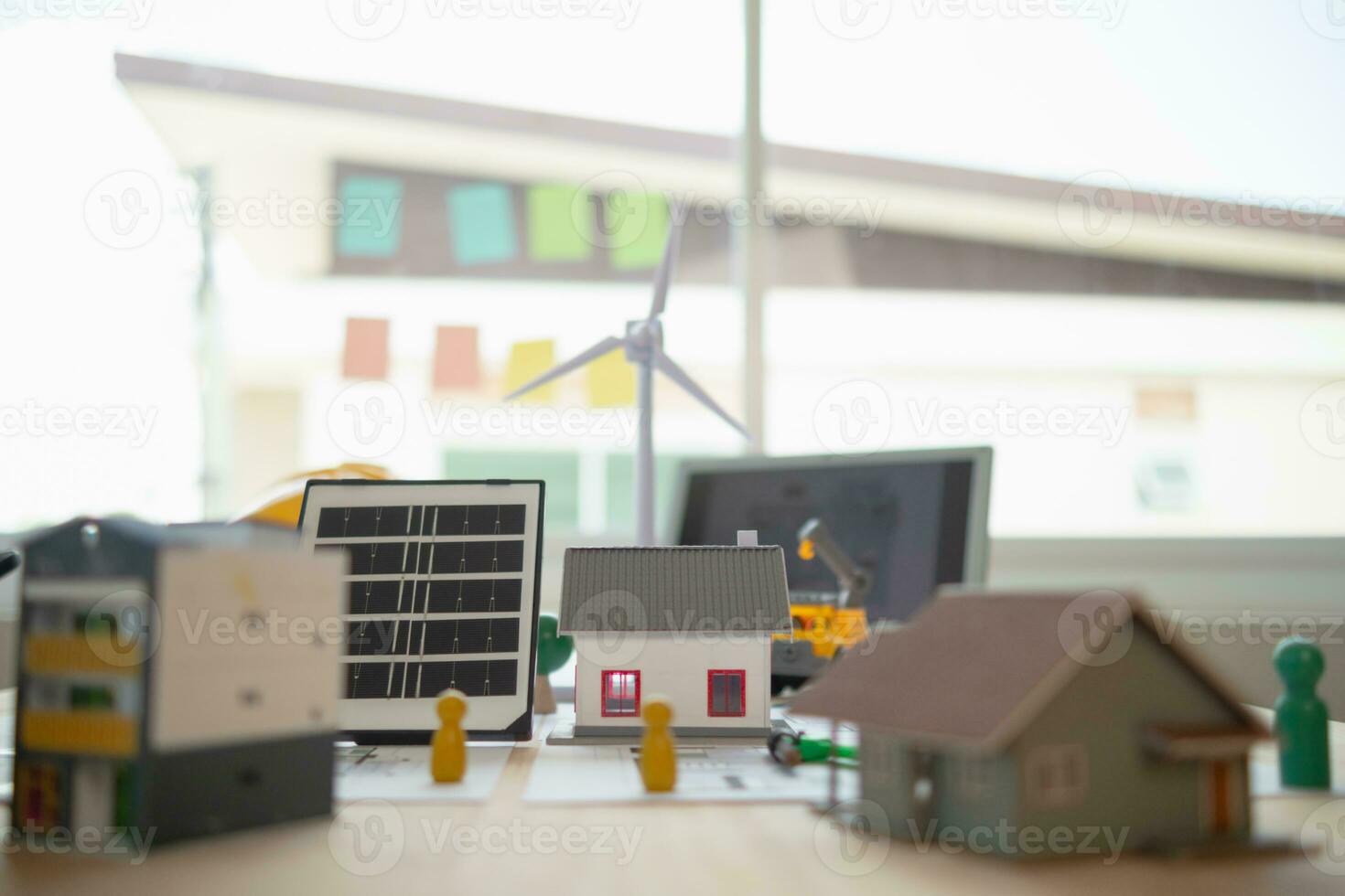 On desk of engineers lay model of house And solar panels to use in planning installation of solar panels to  house in order to get most cost effective energy from installing solar panels. photo