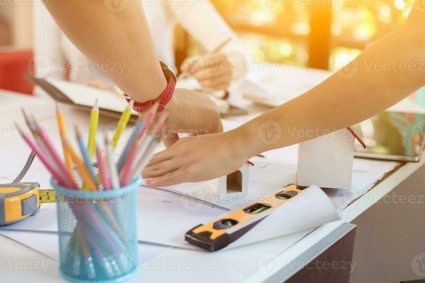 Engineers and designers are discussing the layout of the house and the construction schedule to be completed on schedule. House construction ideas with a team of professional engineers and designers. photo