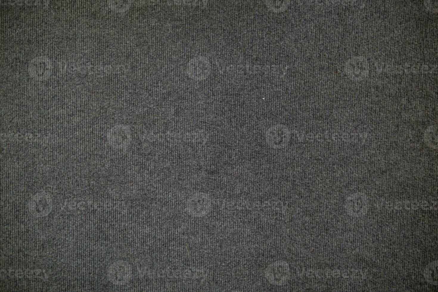 black fiber background is woven into large cloth and is stuffed with black twine to be used to make doormats and floor rugs that are soft to walk on. Black doormat background with Copy Space for text. photo