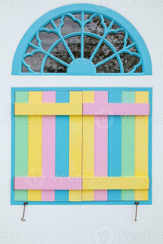 vintage arched wooden windows are painted in beautiful colors and are designed with bright colors on background. Bright rainbow colored windows are design on white background because they are popular. photo