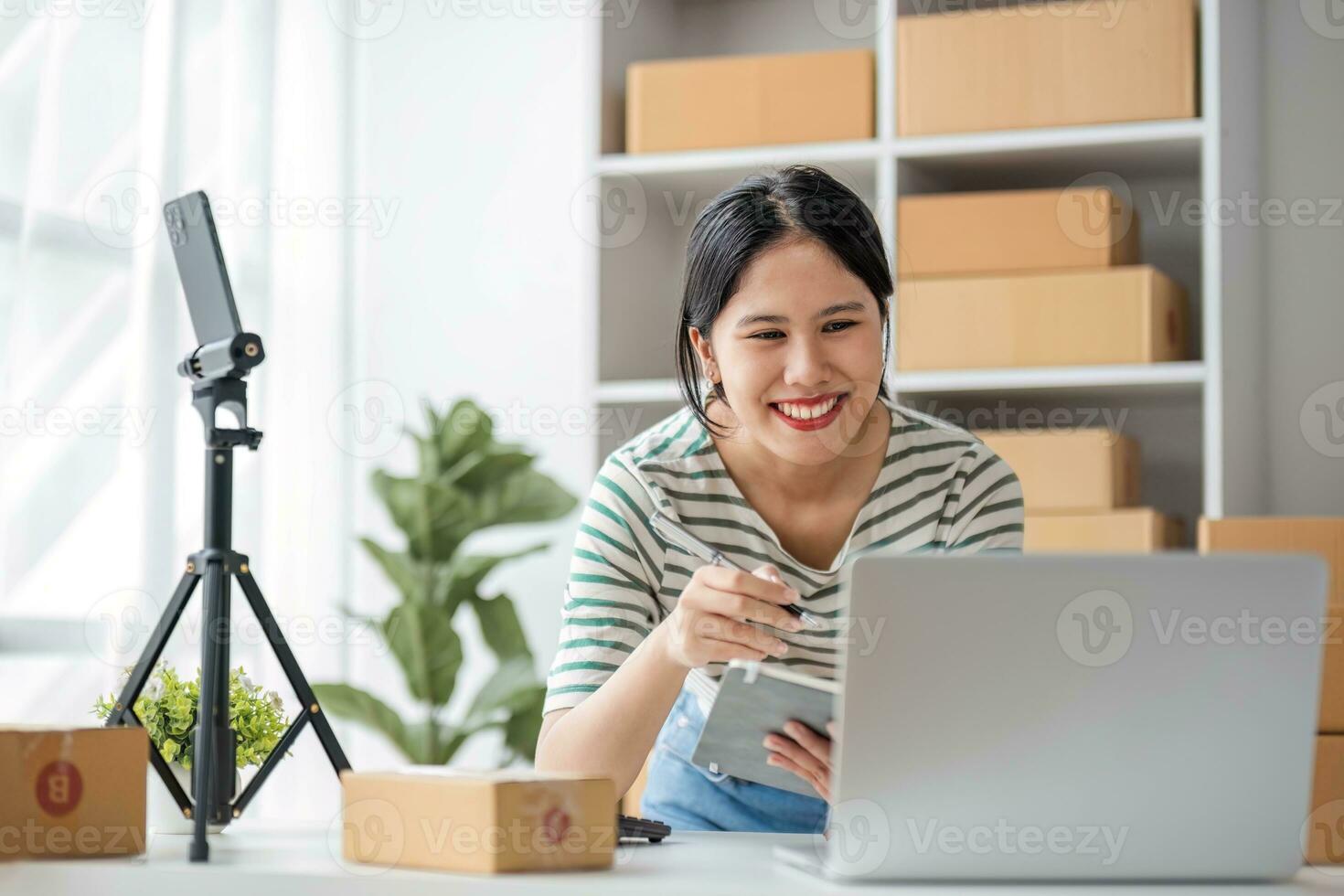 Starting Small business entrepreneur SME freelance, Portrait young woman working at home office, BOX, smartphone, laptop, online, marketing, packaging, delivery, b2b, SME, e-commerce concept. photo