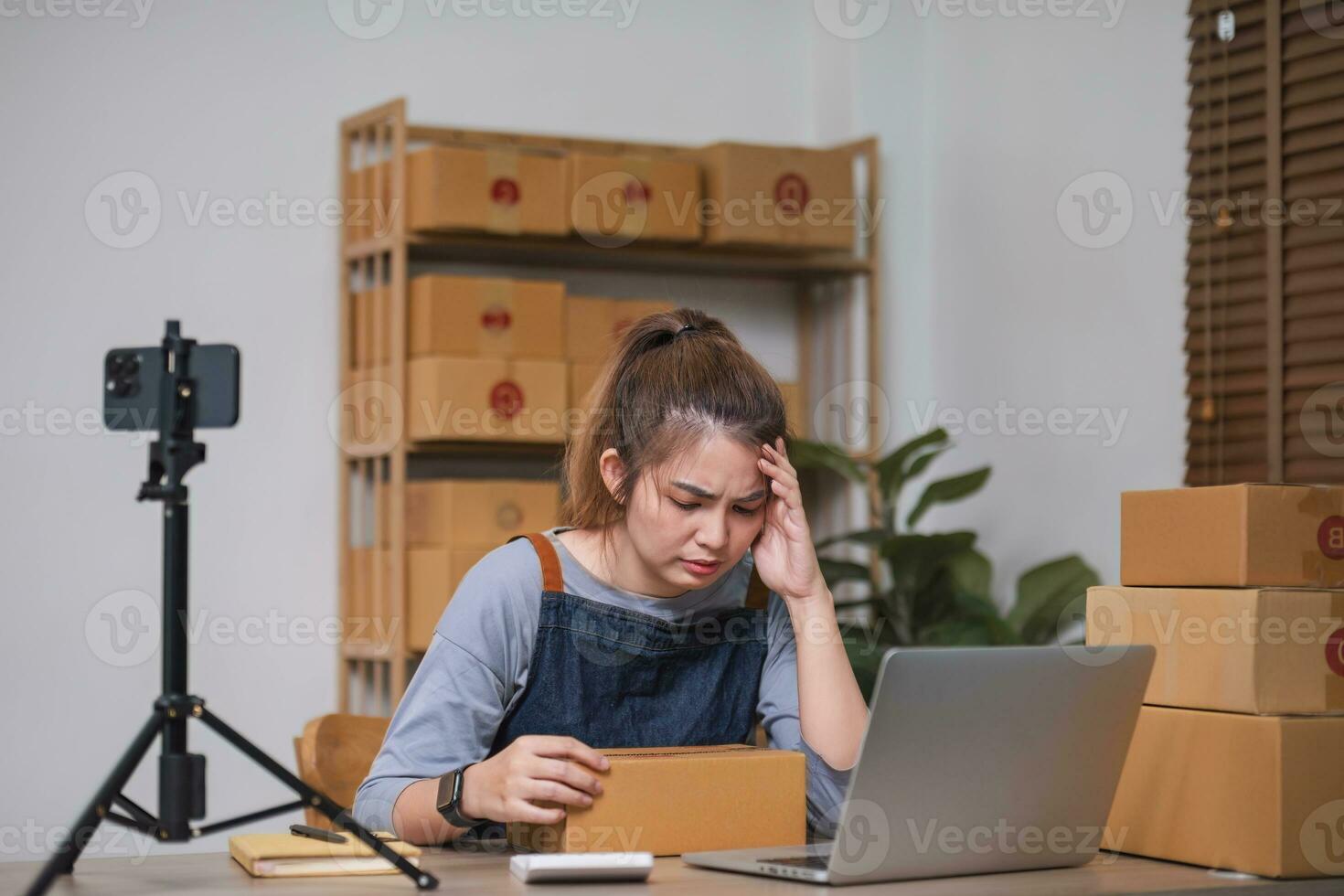 Stress serious asian woman doing clothing business selling online. she using laptop computer. online sell marketing delivery, SME ecommerce concept photo