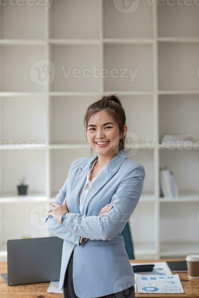 Confident Asian businesswoman standing in office, looking at camera with professional demeanor. modern asian business professional. photo