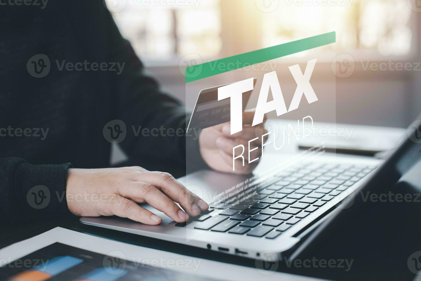 Hand using tablet with bar  TAX REFUND and refund tax of duty taxation business, graphs and chart being demonstrated on the screen media,  tablet pc and selecting tax refund. photo