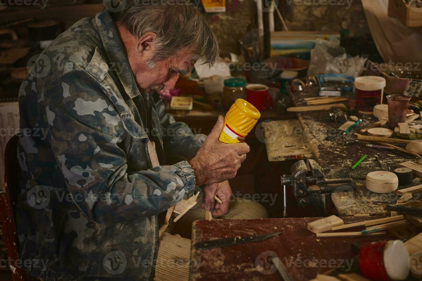 un artesano pegamentos madera piezas dentro un modelo a hacer de madera artículos en el taller. letras, habilidades y aficiones conceptos foto