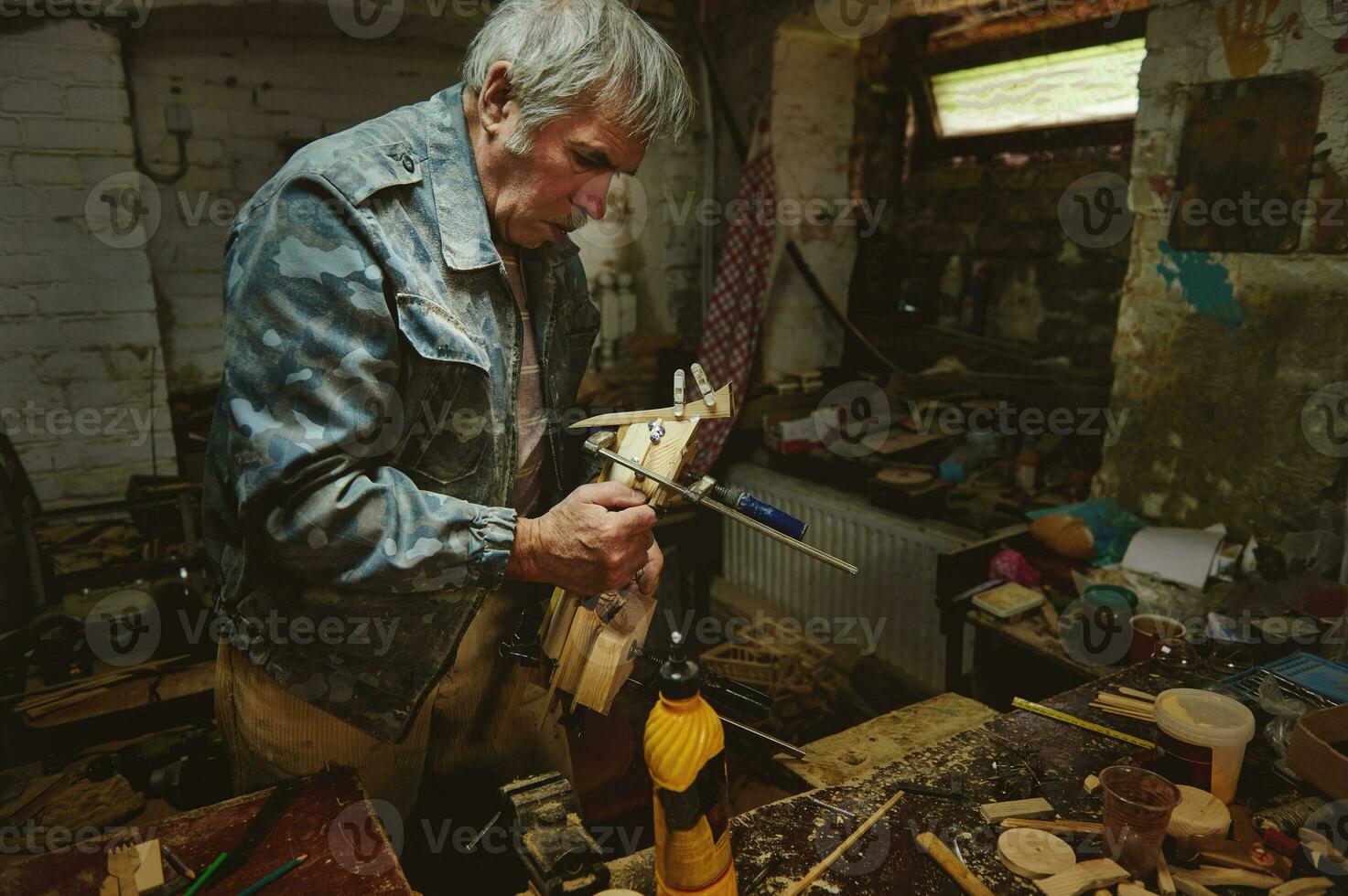 Mature carpenter in action in his workshop. Craftspeople, artist in action, talent, skill and hobby concepts photo