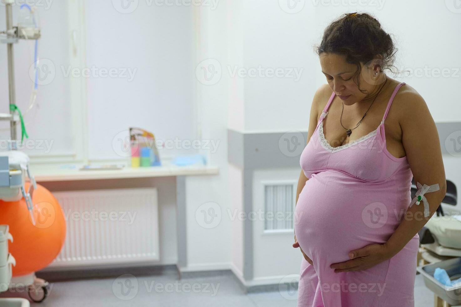 embarazada mujer parto madre con doloroso contracción, conmovedor barriga y mirando abajo. parto proceso a hospital foto