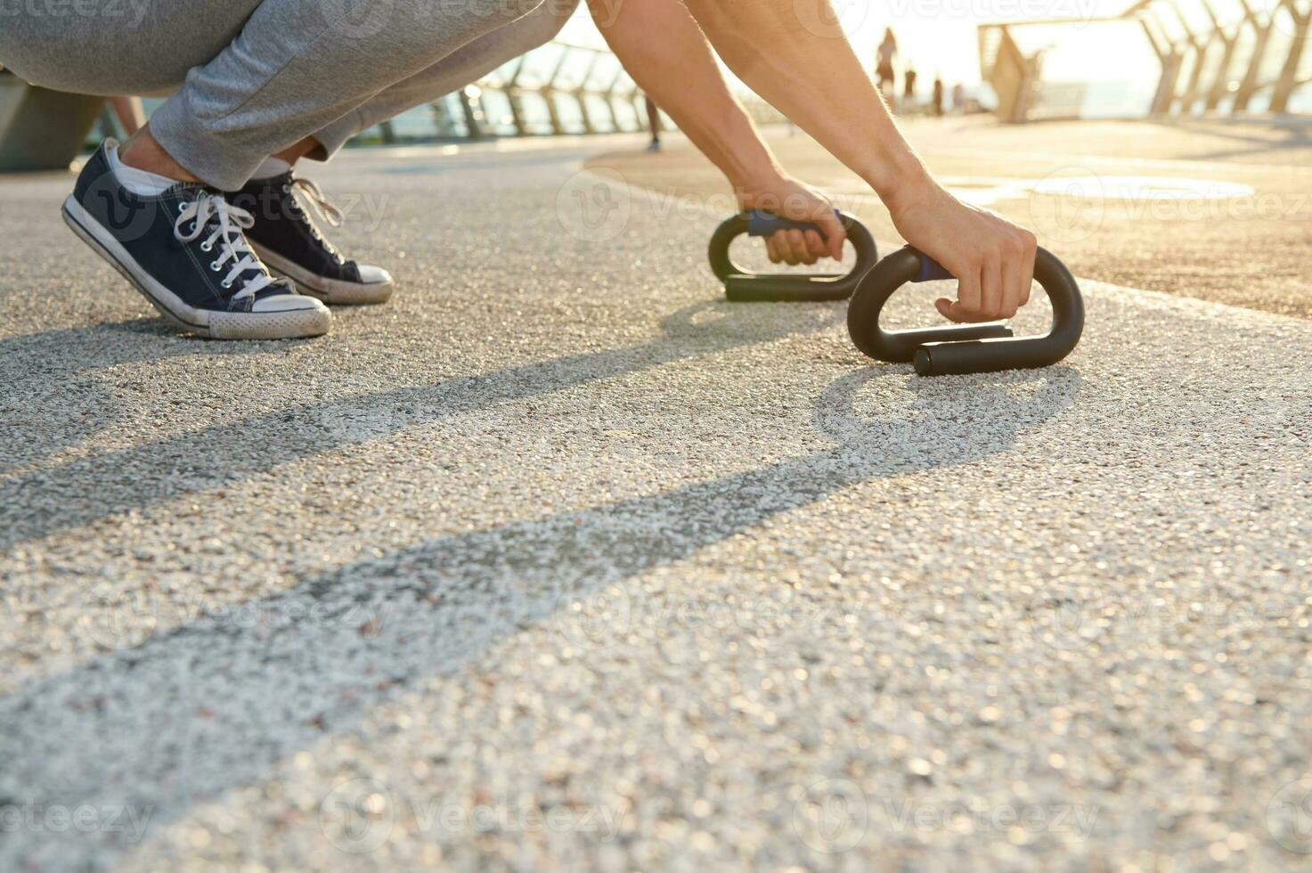 Cropped image of an athlete exercising outdoor, doing push-up exercises. Fitness, sport, endurance, body weight training, outdoor workout, healthy and active lifestyle concept photo