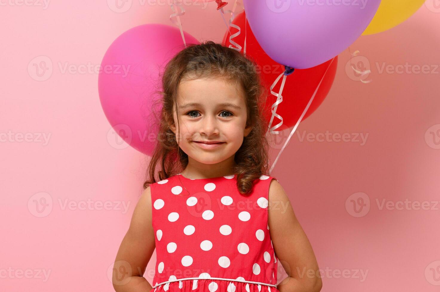 Close-up portrait of beautiful 4 years baby girl, smiling looking at camera, isolated over pink background, copy space. Concept of happy childhood, International Woman's and Children Protection Days. photo