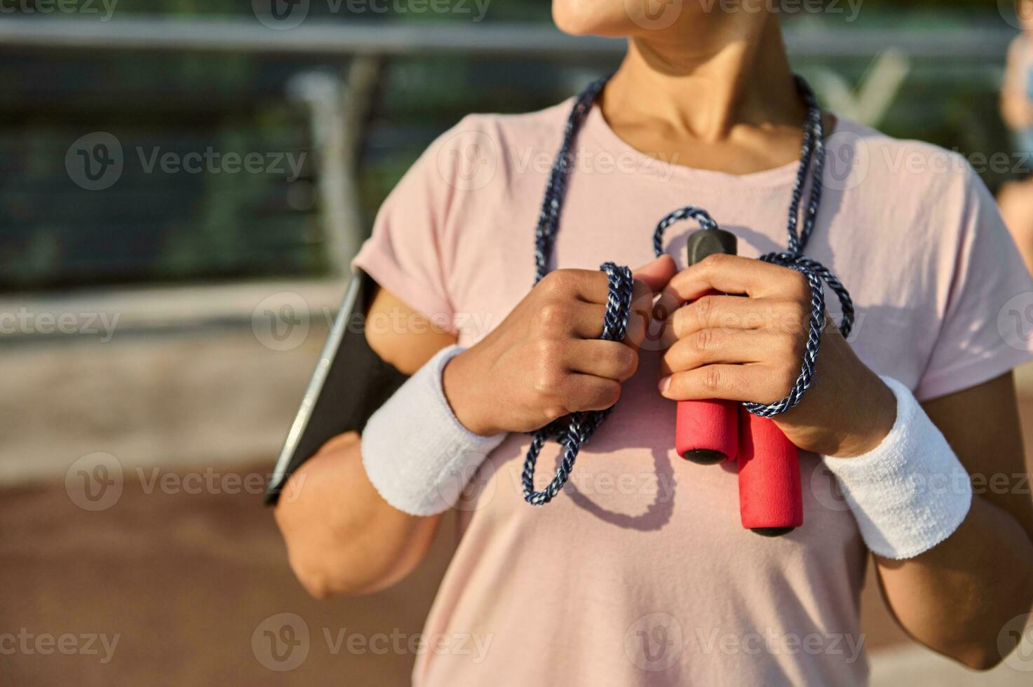 recortado imagen de un irreconocible deportista con un saltando soga, en pie en el moderno vaso ciudad puente, disfrutando Mañana cardio rutina de ejercicio al aire libre foto