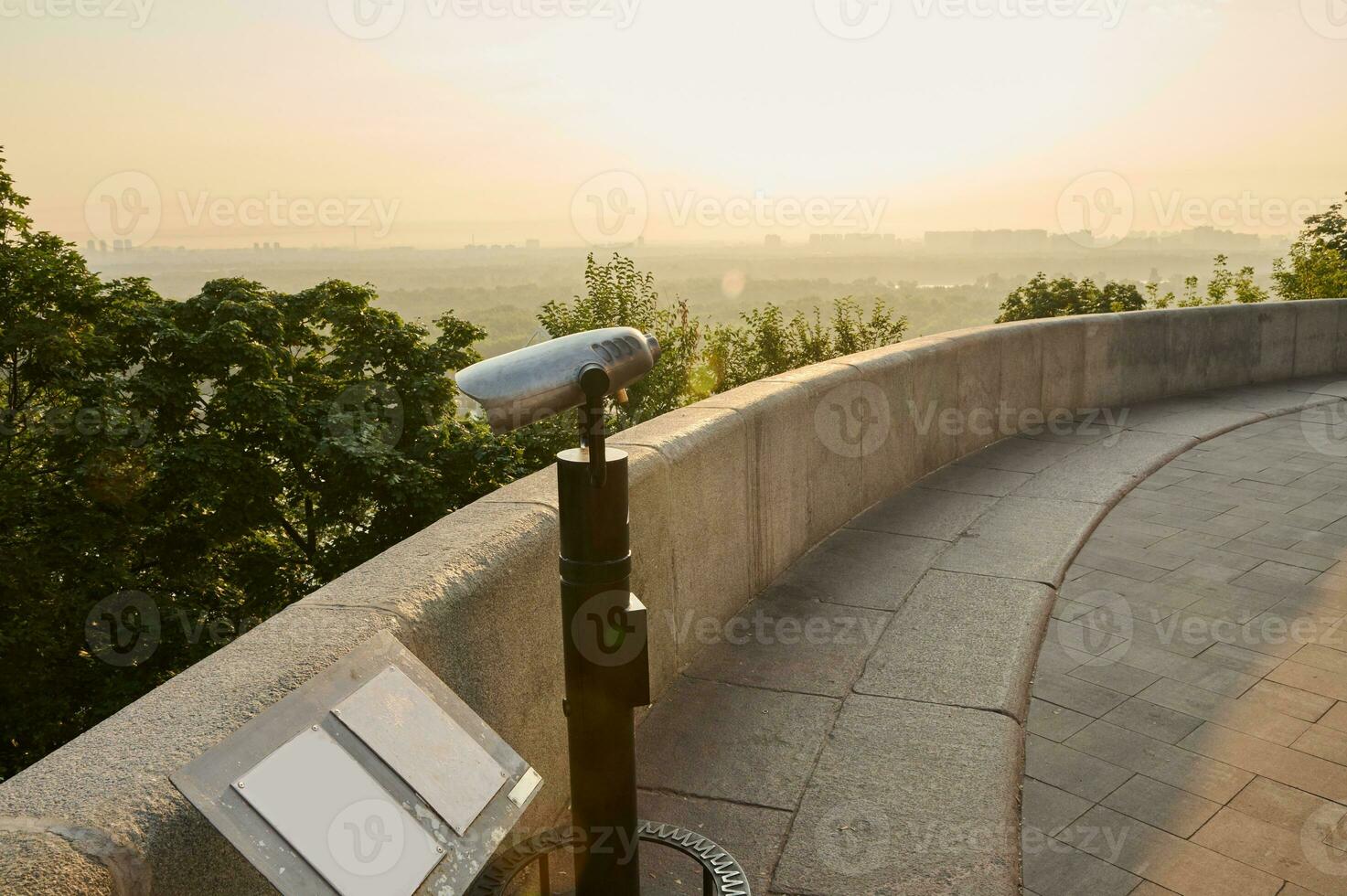 turista moneda telescopio. metal estacionario prismáticos en pie en un alto colina en el punto de vista, para observando el naturaleza de un hermosa antiguo histórico ciudad con vista a el río foto