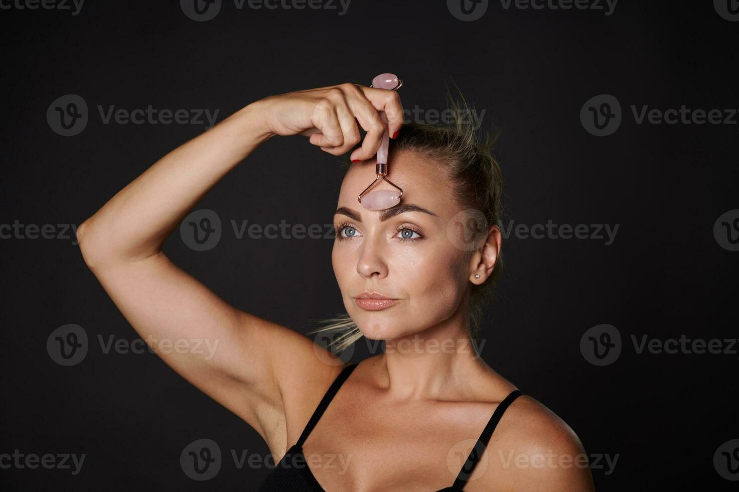 disparo a la cabeza bonito mujer haciendo un linfático drenaje facial masaje con un rodillo masajeador belleza spa tratamiento. antienvejecimiento, alisado, rejuvenecimiento belleza terapia foto