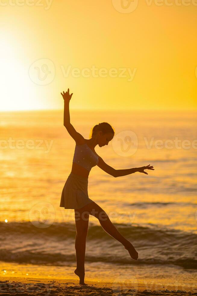 Happy teen girl enjoy tropical beach vacation at sunset photo