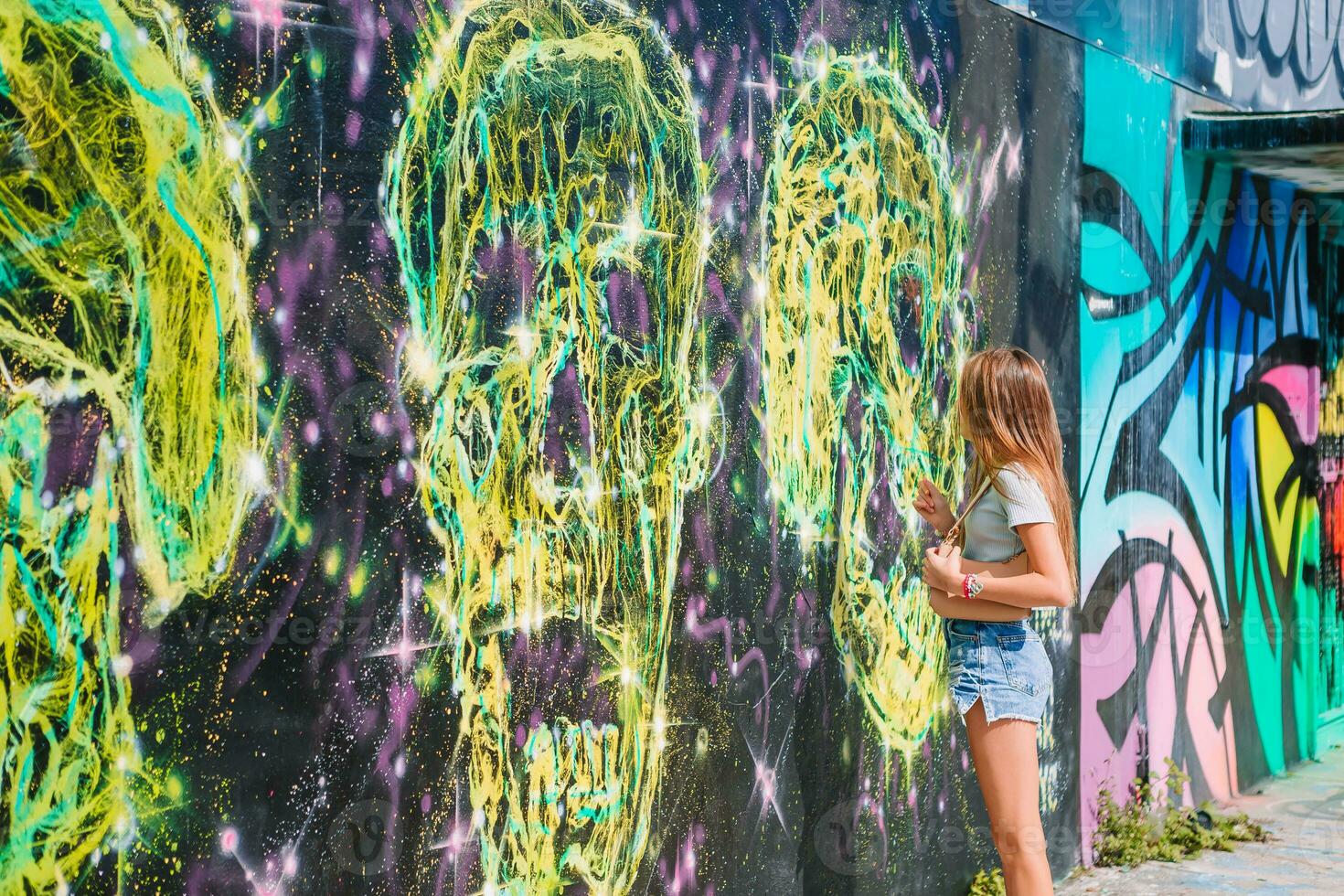 a girl standing in front of graffiti wall photo