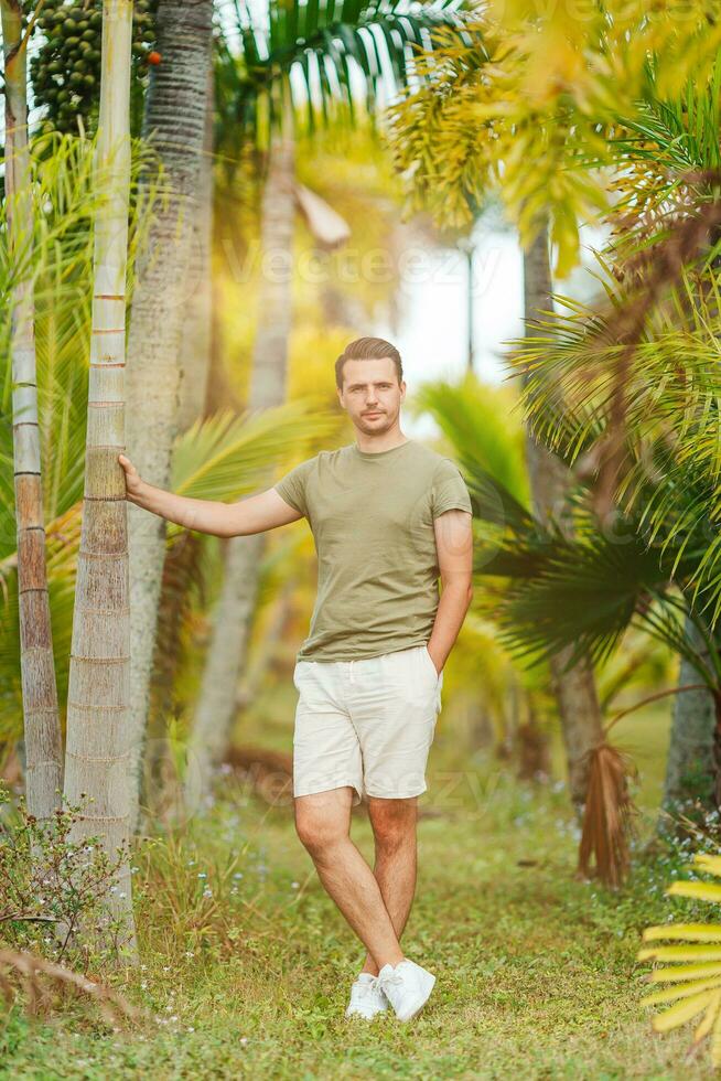 un hombre en pie en frente de palma arboles foto