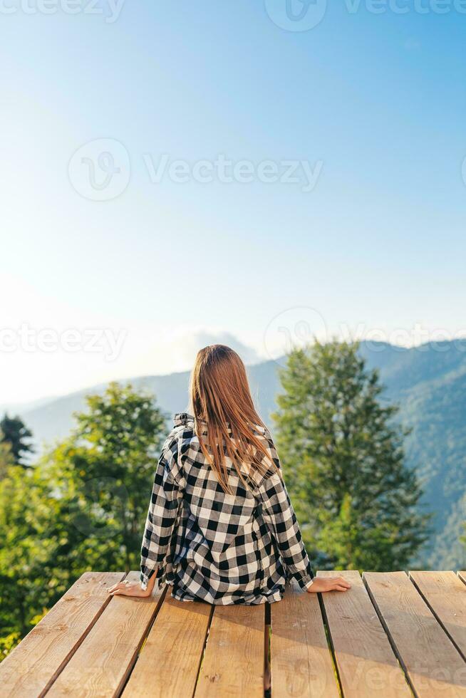 Beautiful happy girl in mountains in the background of fog photo