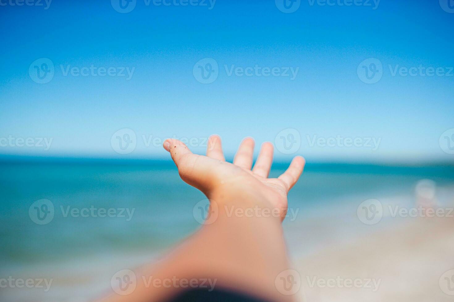 Closeup hand on background of the sea and sky photo