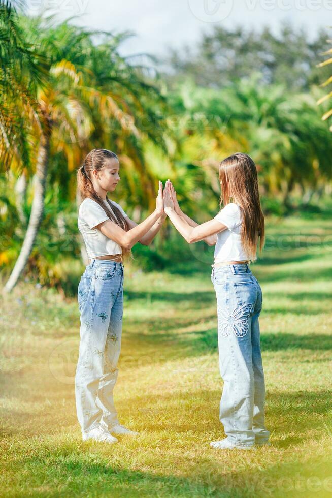 dos muchachas en pantalones en un campo con palma arboles foto