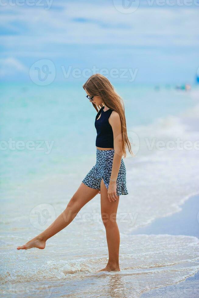 adorable jovencita en la playa disfruta de sus vacaciones de verano foto