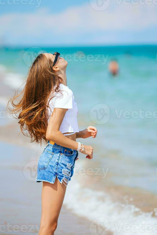 adorable jovencita en la playa disfruta de sus vacaciones de verano foto