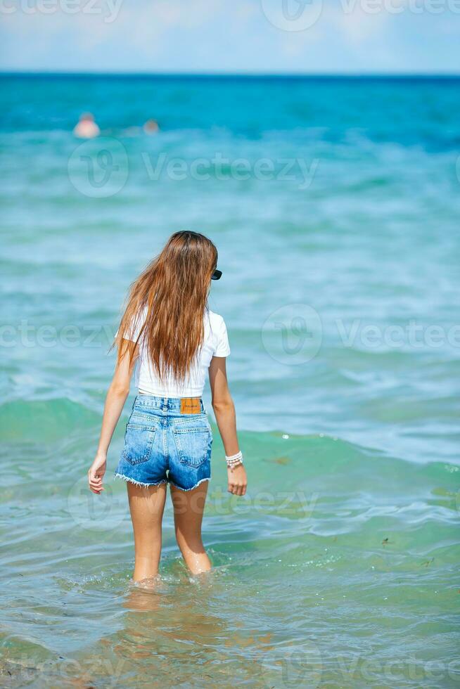 adorable jovencita en la playa disfruta de sus vacaciones de verano foto