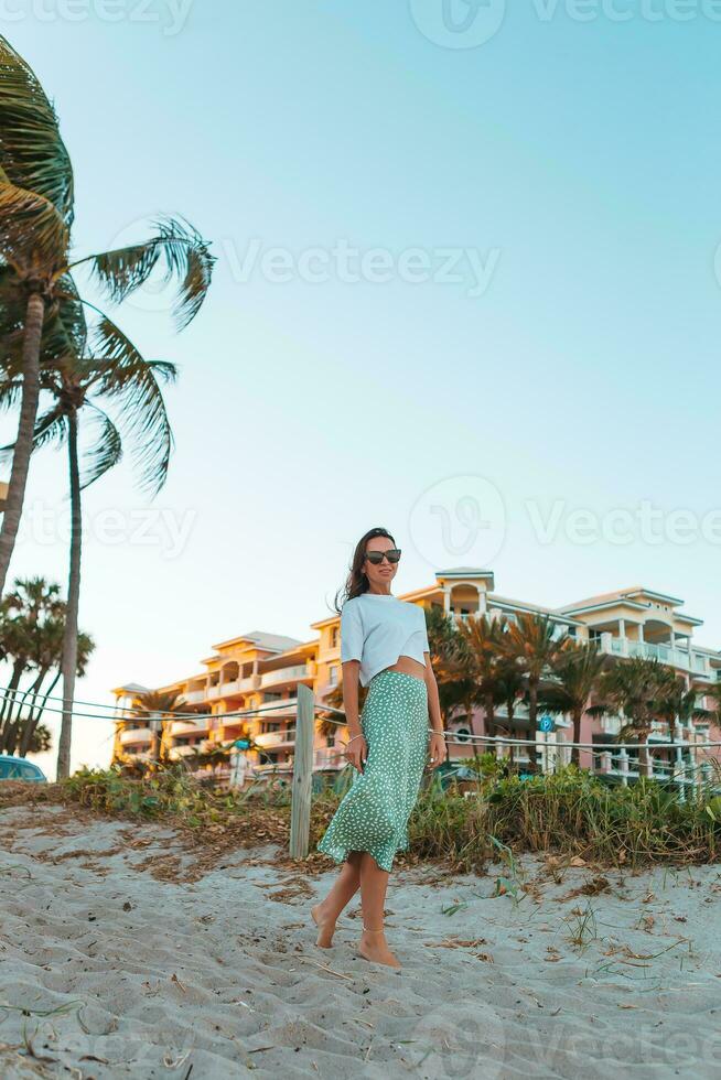 Happy woman enjoying beautiful sunset on the beach photo