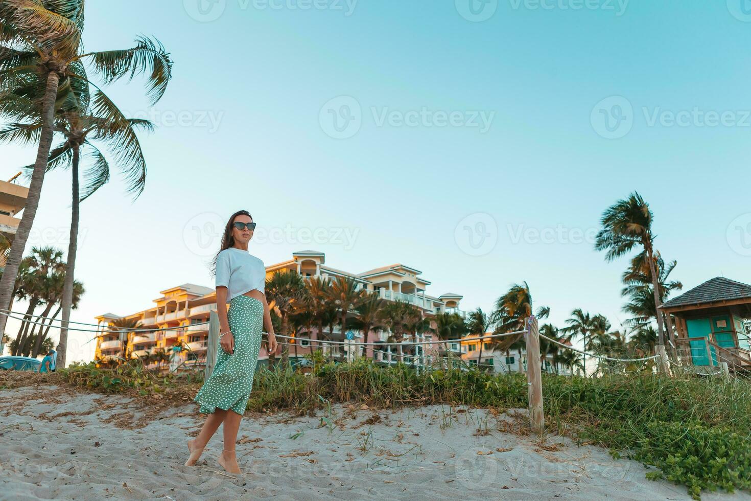 Young happy woman on the beach enjoy her summer vacation photo