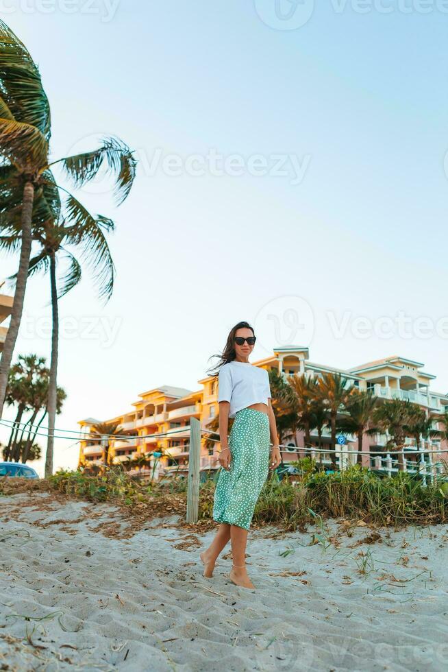 Young happy woman on the beach enjoy her summer vacation photo