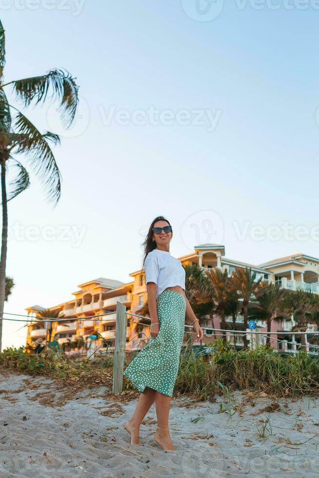 Young happy woman on the beach at sunset enjoy her sky view photo