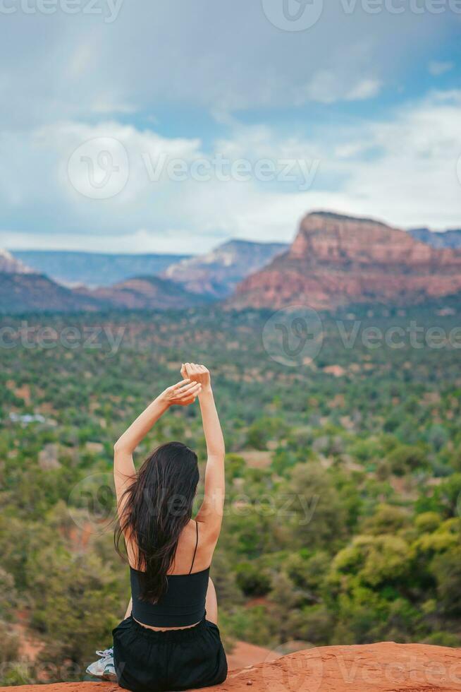 Woman enjoys the view of the Sedona landscape from the top of the Bell Rock hiking trail, famous for its many energy vortexes and red rocks. photo