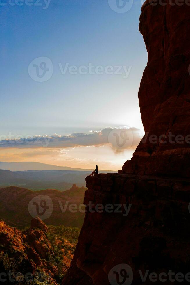 joven caminante mujer en el borde de un acantilado a catedral rock en sedona, Arizona. ver desde escénico catedral rock en sedona con azul cielo en Arizona foto