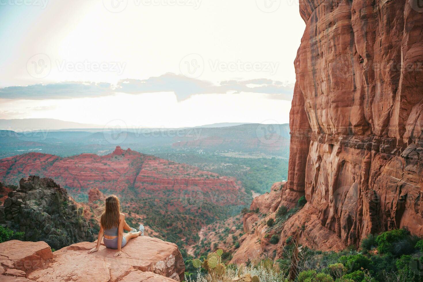 Little girl on the edge of a cliff at Cathedral Rock in Sedona, Arizona. View from Scenic Cathedral Rock in Sedona with blue sky in Arizona photo