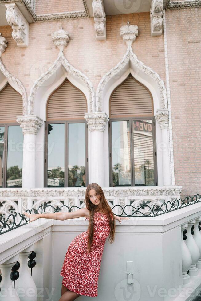 Beautiful young girl background the famous hotel in Las Vegas, standing in the busy city. Famous tourist attraction in USA on vacation in Las Vegas. photo