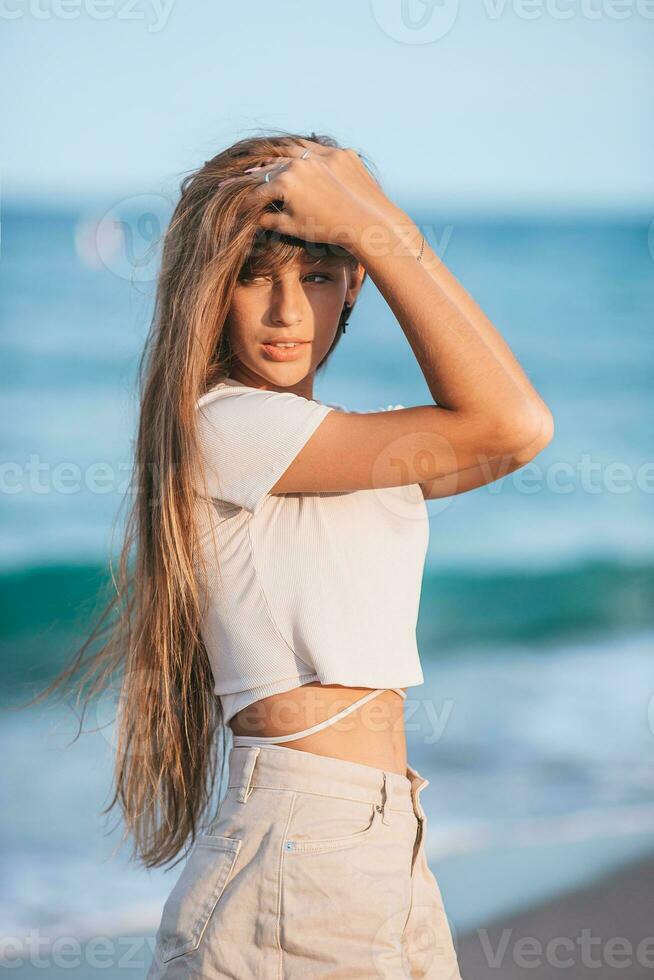 hermosa adolescente niña en tropical costa a puesta de sol foto