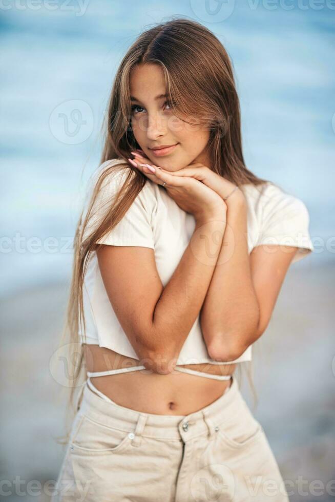 Beautiful teenager girl on tropical seashore at sunset photo