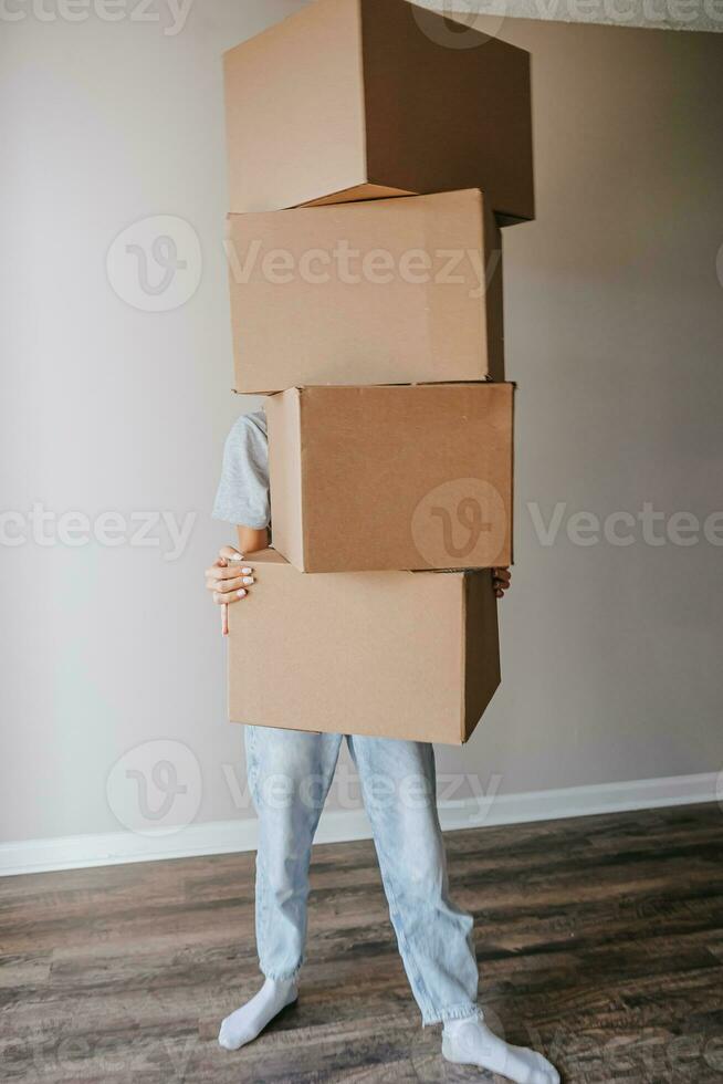 Happy adorable girl with cardboard boxes in new house at moving day photo