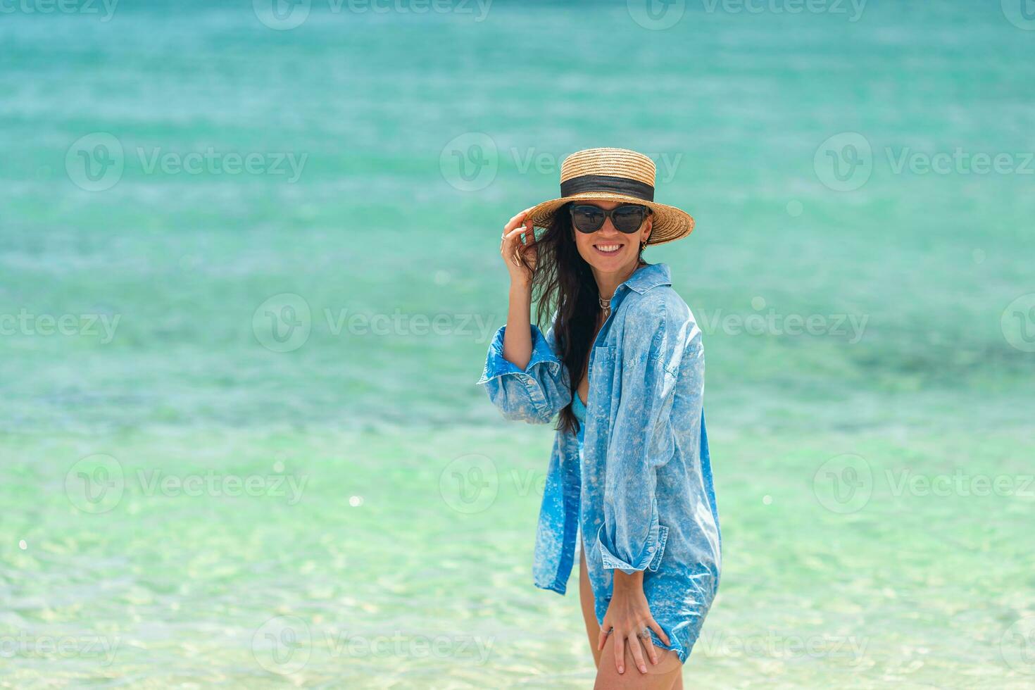 Young happy woman on the beach enjoy her summer vacation. Girl is happy and calm in her stay on the beach photo