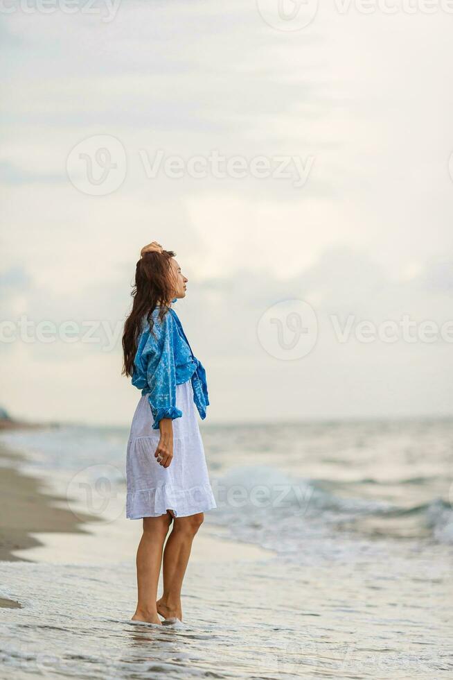 Happy woman enjoying beautiful sunset on the beach photo
