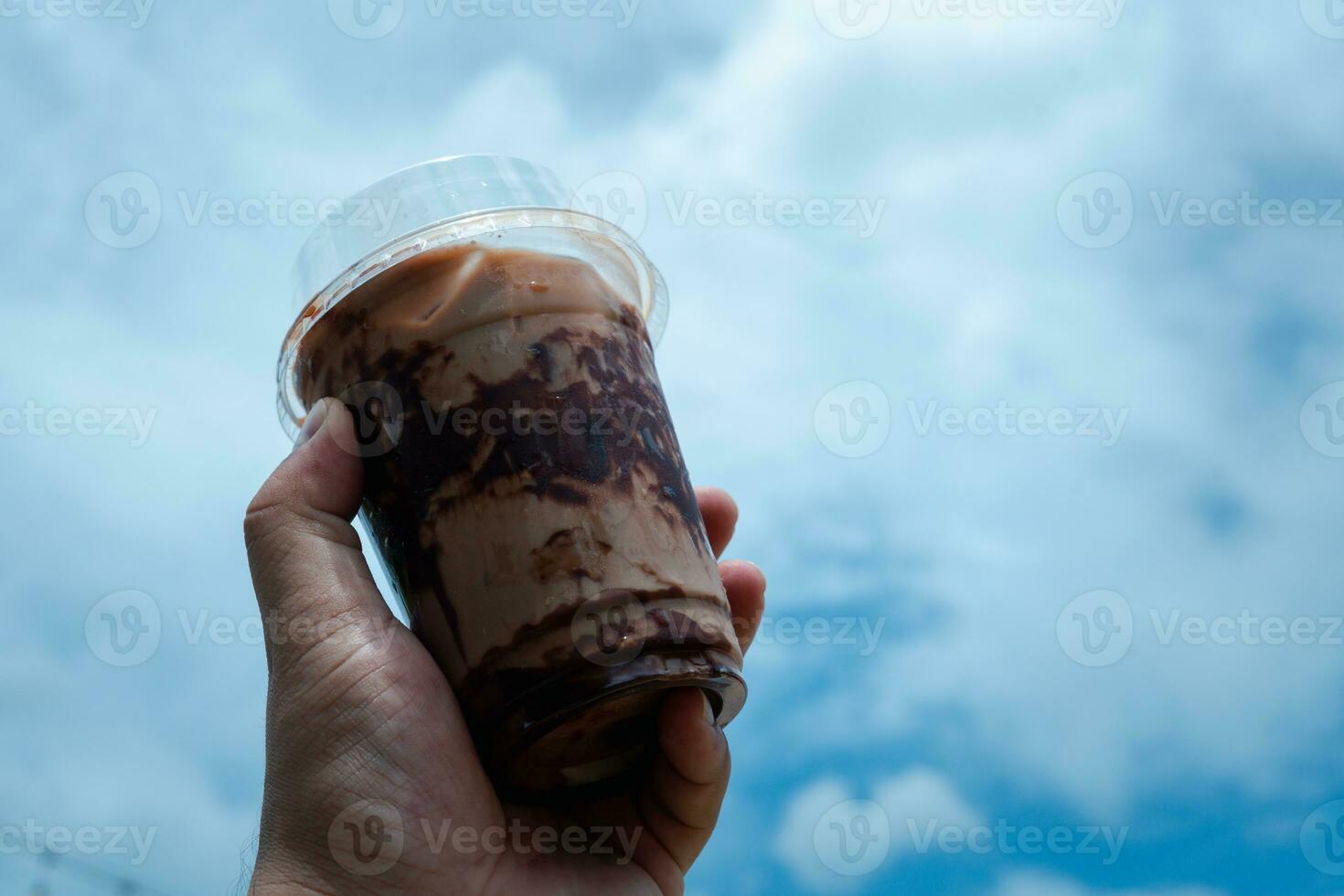 Hand holding iced mocha with showing the texture and refreshing look of the drink photo