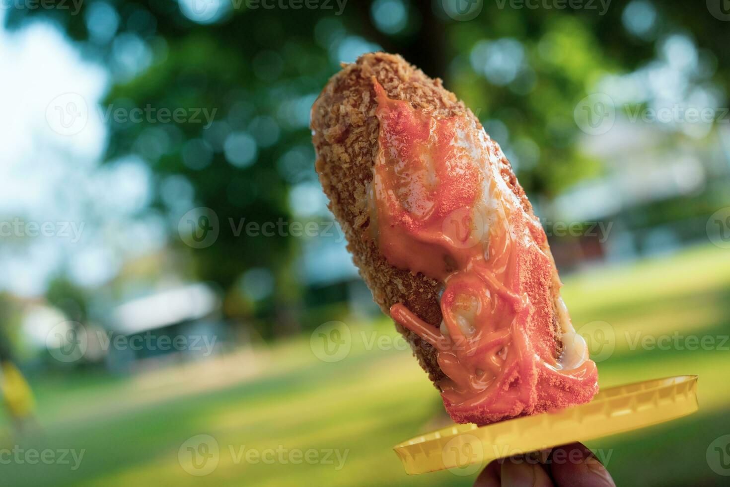 Delicious corn dogs in hand photo