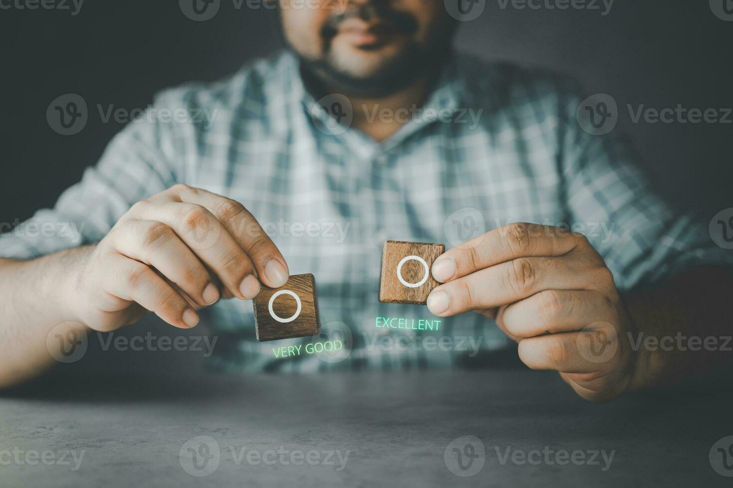 Smiling man showing a wood block with an empty check box between very good or excellent photo