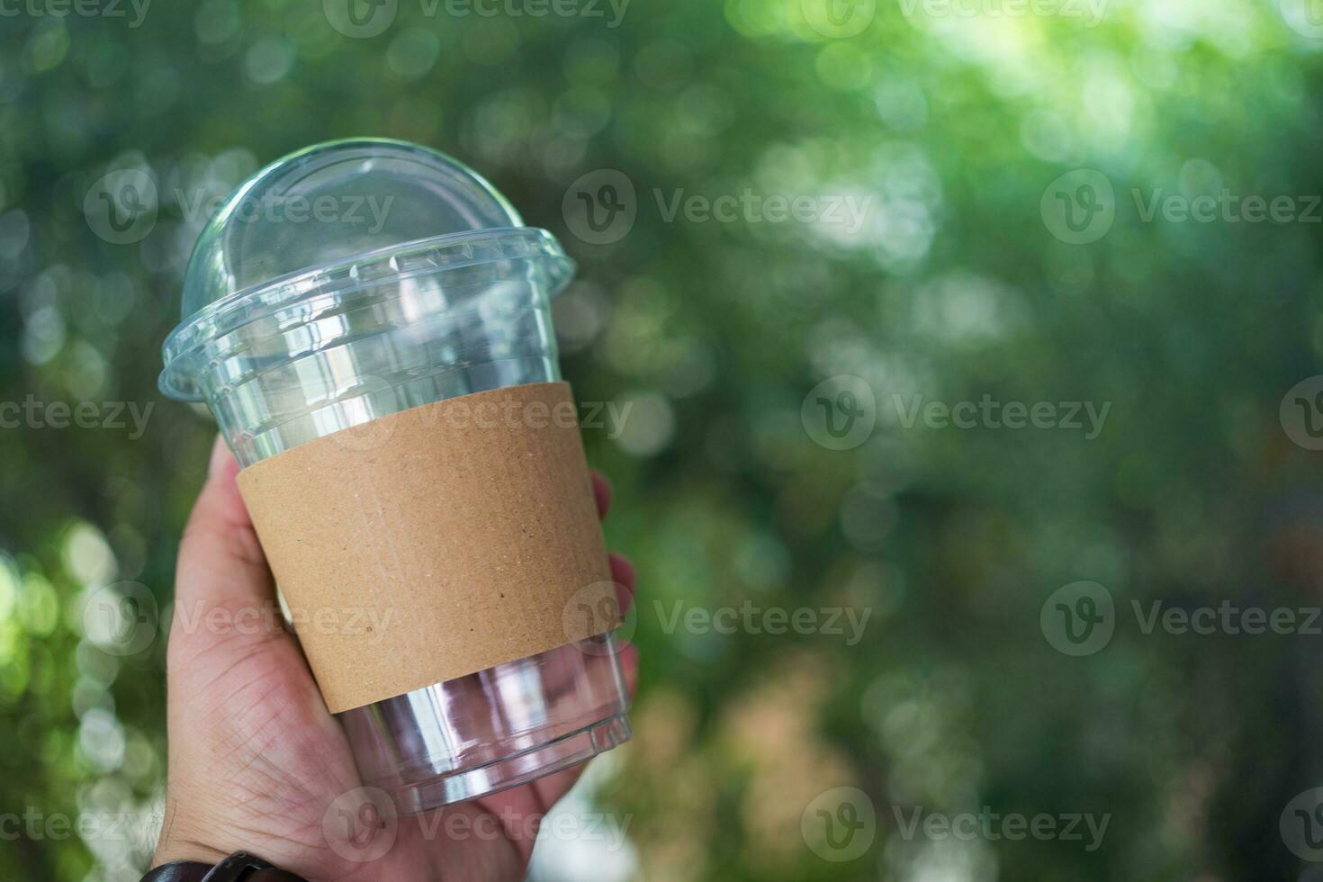 Empty disposable cold coffee or drink cup have blank brown cardboard sleeve photo