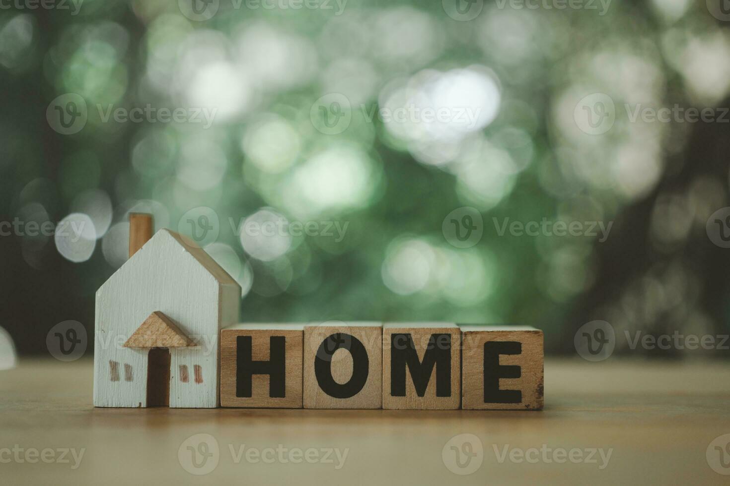 Wooden blocks wording HOME and small house model. Real estate investment trust concept. photo