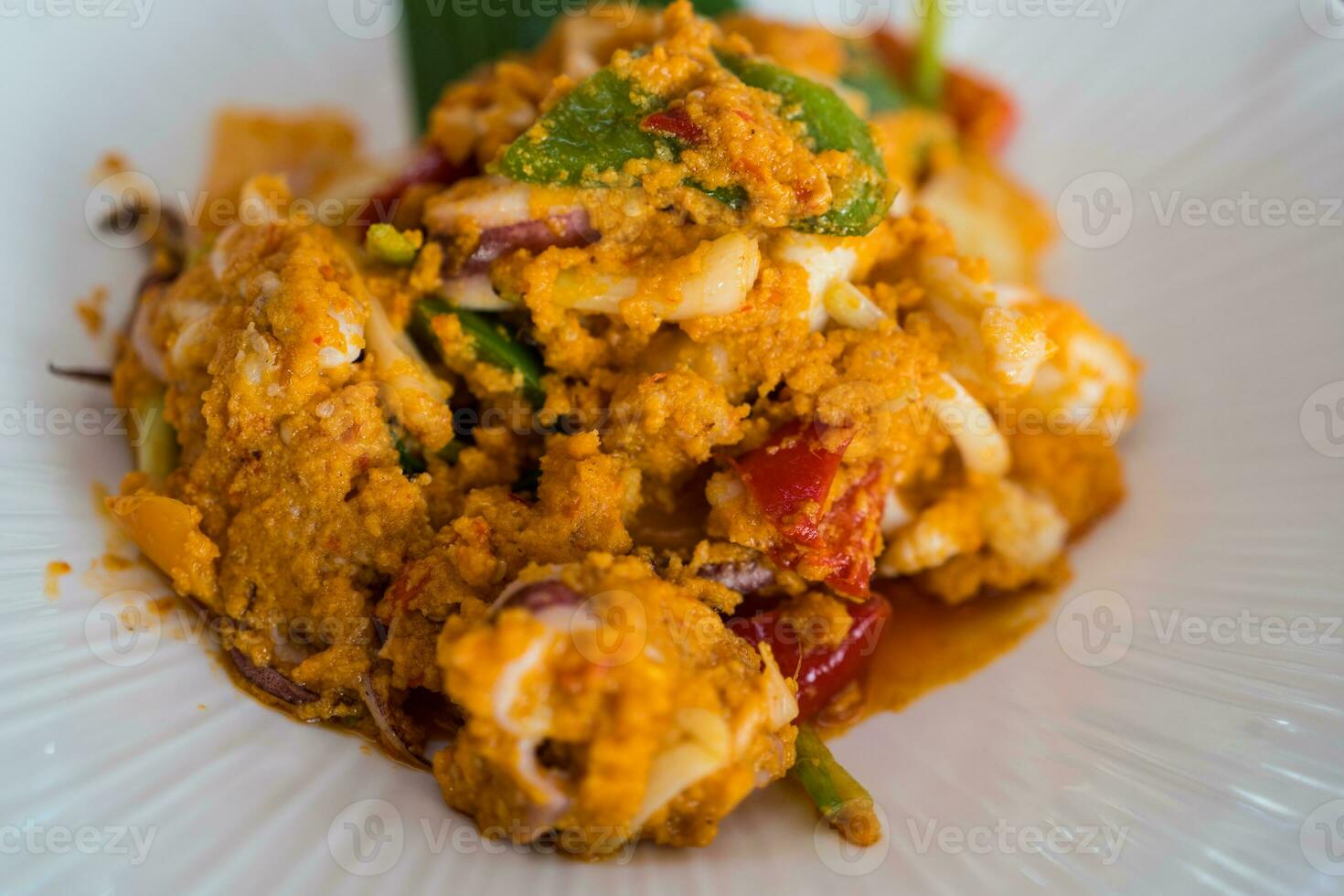 Salted squid calamari fried with salted egg on white plate. photo